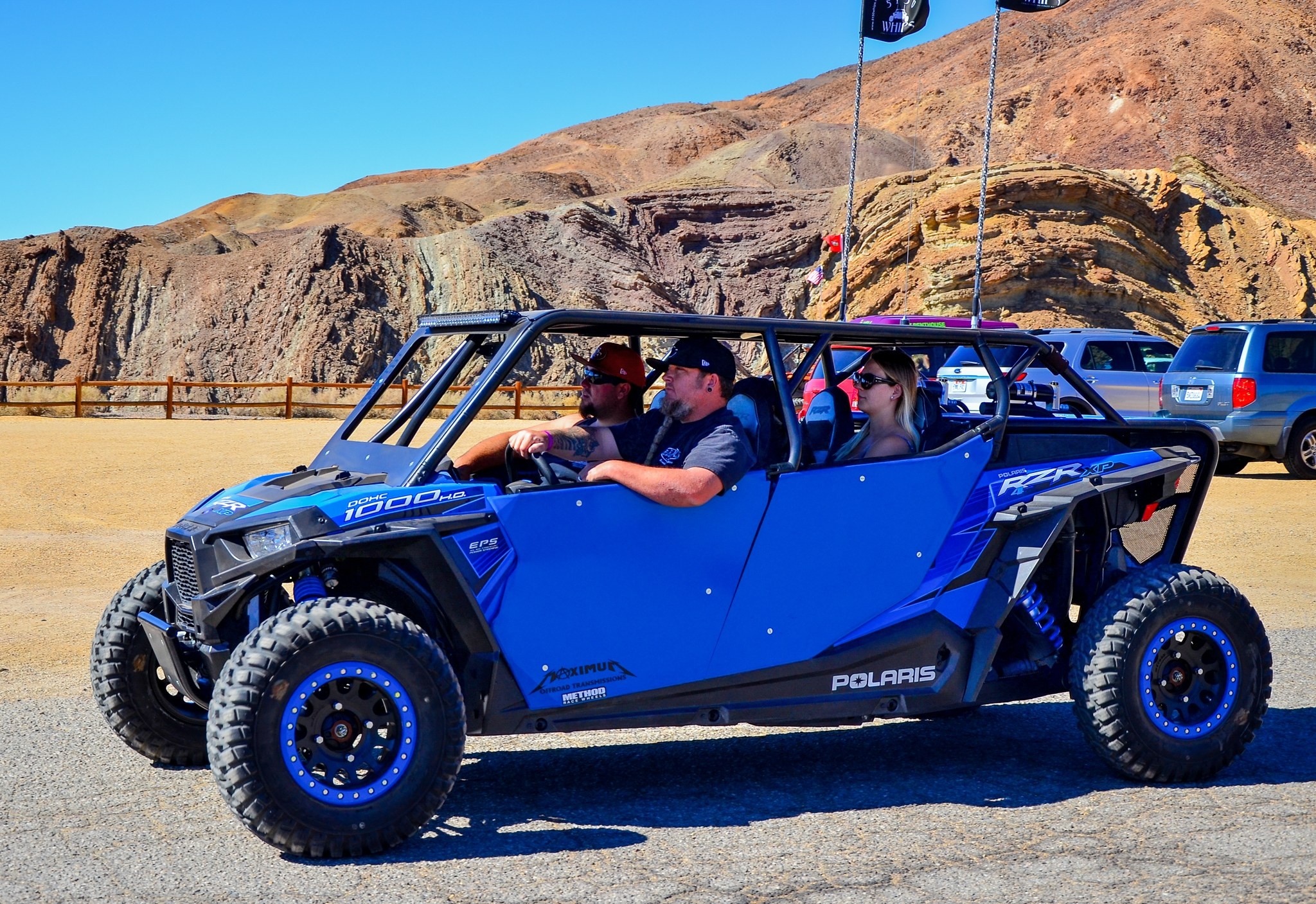 Buggy azul con cuatro personas en un camino de tierra entre montañas